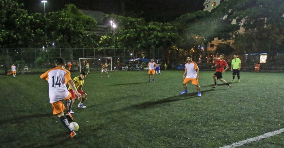 Pelada à noite sob os refletores — o campo iluminado e a galera em campo